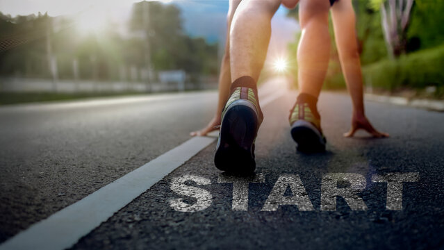 A runner in starting position on an outdoor road with strong sunlight, symbolizing motivation, determination, and the beginning of a new journey. Ideal for concepts of start, goal setting, fitness, an