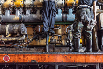 A train engineer technician is working on the maintenance of an old train.