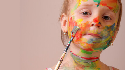 Toddler experimenting with bright artistic paints. Copy space.