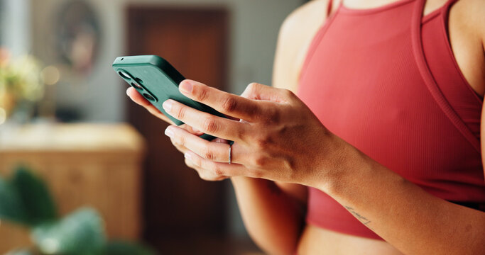 Woman, hands and research with phone for health tips, workout routine or fitness guide in home. Closeup, female person or typing with mobile smartphone for online app or exercise schedule in house