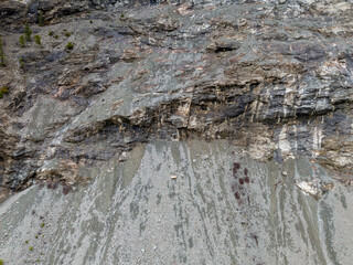 Rugged Rock Face With Multicolored Slopes and Coarse Texture in Natural Cliff Scene