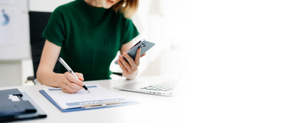 Obraz premium Businesswoman hand working digital marketing media in virtual screen with mobile phone and modern compute with VR icon diagram at office