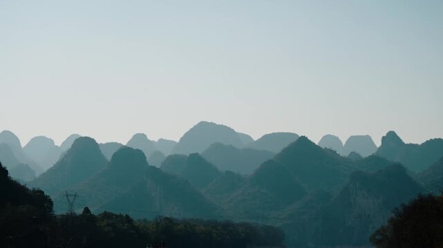 Rows of misty karst peaks fade into the distance above forested slopes near the Li River, China.