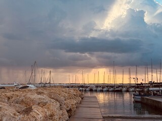 Golden sunset over the calm sea in Zygi, with fishing boats and the marina glowing in warm evening light