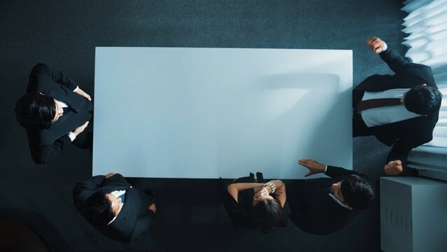 Top down aerial view of business team shaking hand and clapping hands to celebrate young businesswoman getting promotion. Diverse business people congratulate for successful project. Directorate.