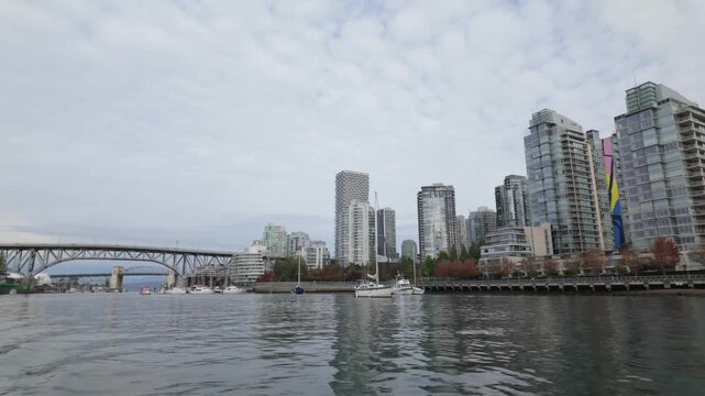 Gimbal shot from a moving boat of David Lam Park along False Creek during autumn in Vancouver, British Columbia, Canada. 4K