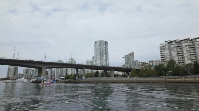 Gimbal shot from a moving boat of an Aquabus ferry heading towards Cambie Bridge on False Creek in Vancouver, British Columbia, Canada. 4K