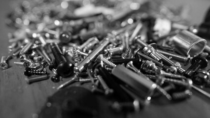 Black and white close-up of metal nuts and bolts in workshop