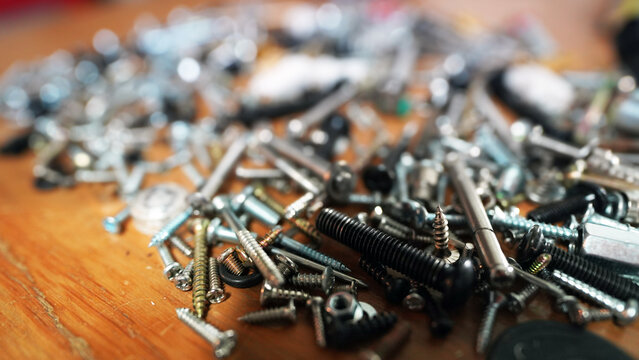 Close-up of silver metal nuts and bolts in industrial workshop