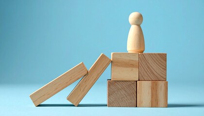 Wooden figure atop block tower with falling dominoes.