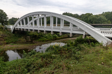 Obraz premium A scenic view of the historic Rainbow Curve Bridge (Brush Creek Bridge) near Galena, Kansas. This white concrete Marsh Arch bridge, built in 1923, is the last of its kind remaining on Route 66.