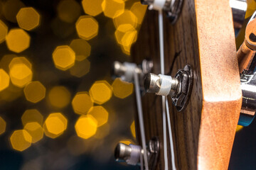 ukulele on a blurred background with highlights. head, headstock , close-up