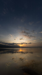 Naklejka premium Calm Lake at Sunrise With Cloud Reflections