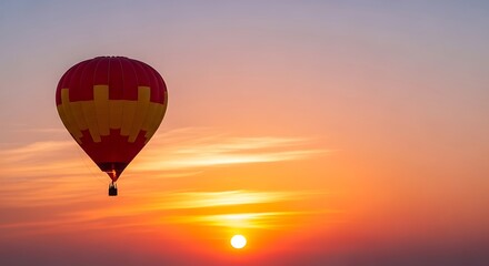 Fototapeta premium Red and Yellow Hot Air Balloon Flying at Golden Sunset 