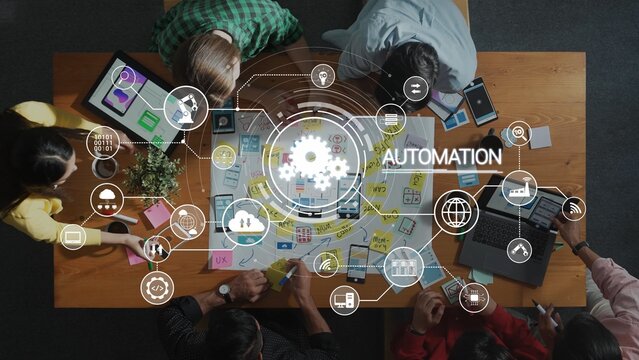 A diverse team collaborates around a wooden table, discussing automation strategies using digital tools and visual aids, highlighting teamwork and creativity in an office setting. Raster - Powered by Adobe