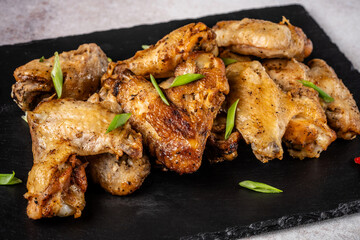 Roasted chicken wings on slate