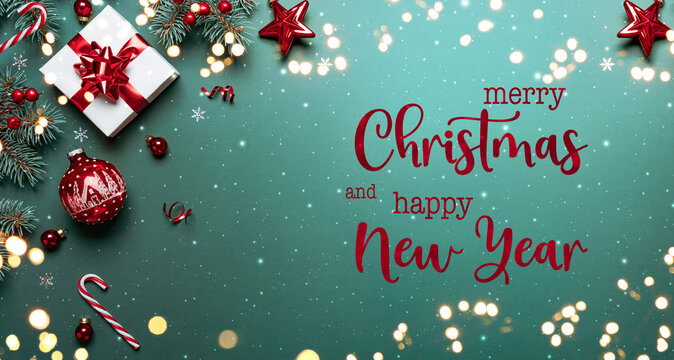 Merry Christmas and Happy New Year text on green background with gift boxes, ribbons, red decoration, fir branches, bokeh, sparkles and confetti. Xmas and Winter holidays. Christmas time, top view - Powered by Adobe