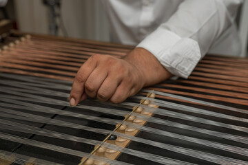 a person playing a cimbalom, also known as a hammered dulcimer. It is a string instrument popular in Romania,2025