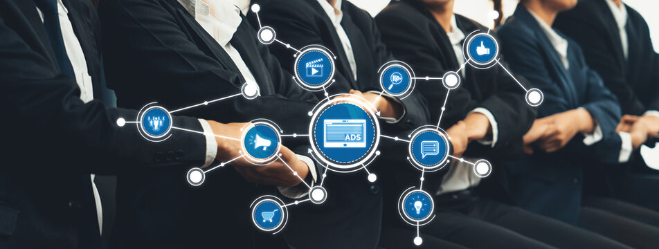 A group of business professionals actively participating in a digital advertising strategy session, showcasing interactive elements and networking connections illustrating modern marketing. Amity - Powered by Adobe