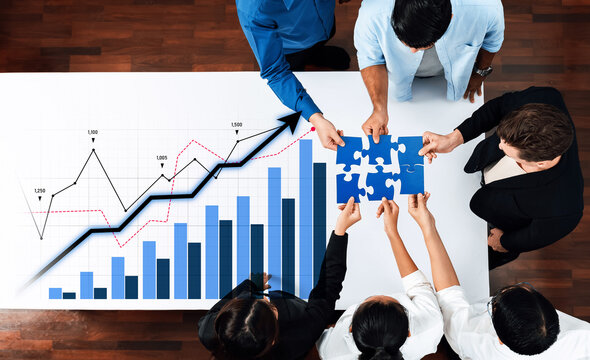 A diverse business team collaborates at a modern office table, assembling puzzle pieces alongside a growth chart, symbolizing strategic planning and collective success. Scalp