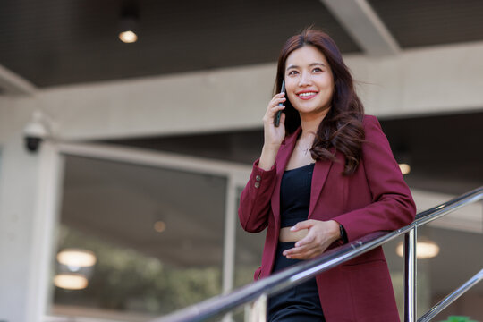 Young businesswoman talking on smartphone in urban setting - Powered by Adobe