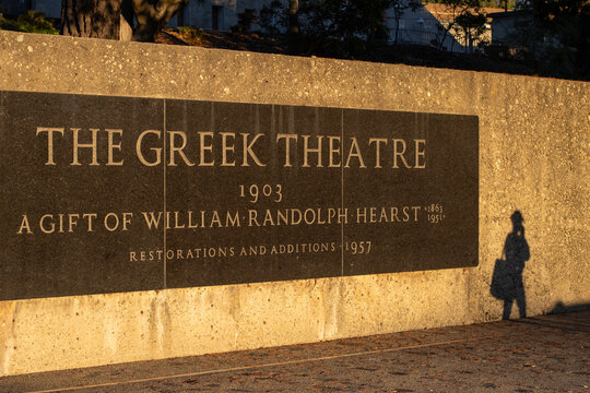 Berkeley, CA, USA - Nov 20, 2023: A college student walks past the Greek Theatre sign on the UC Berkeley campus at dusk. UC Berkeley is a public land-grant research university in Berkeley, California.