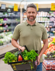 Organic food basket. Man in grocery store. Man shopping with vegetable basket in supermarket. Grocery consumer. Man shopping at grocery store. Healthy lifestyle. Small grocery shop