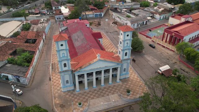 Stunning aerial tracking shot of the Sagrado Coraz&oacute;n de Jes&uacute;s Cathedral, a major landmark with a red roof and twin neoclassical towers, located in Cuman&aacute;, Venezuela.