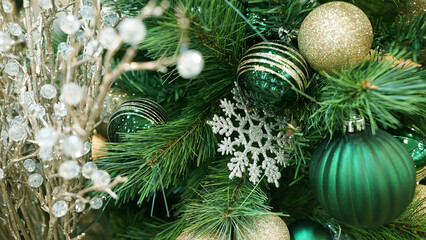 Vibrant green ornaments and ribbons decorating holiday Christmas tree