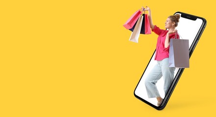 Happy woman with shopping bags on screen of mobile phone on yellow background with space fore text