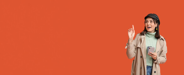 Young woman with credit cards and mobile phone on red background