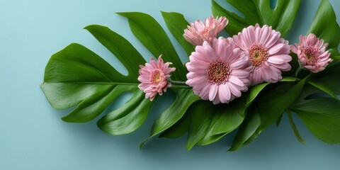 A bouquet of pink flowers is arranged on a green leaf