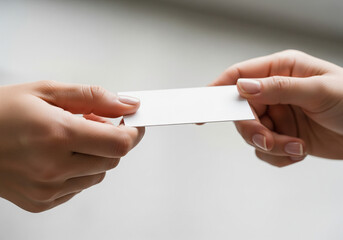 A close-up shot of two individuals exchanging a blank business card