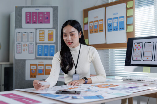 Asian woman developing mobile application ui ux prototype