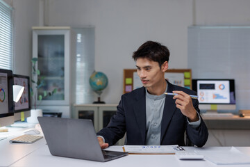 Young businessman analyzing financial data at modern office