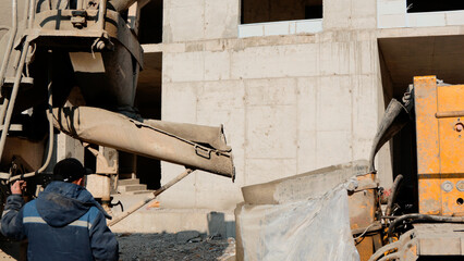 Concrete is being poured from a chute into a form or container