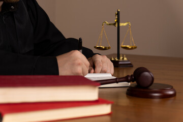 woman in a robe is performing judicial duties using law books, scales of justice