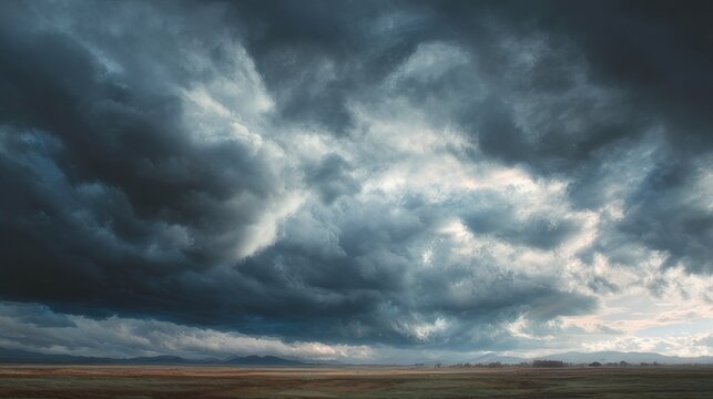 Dramatic cloud-filled landscape over rolling hills with vibrant natural scenery and soft atmospheric light at sunrise, capturing serene outdoor beauty and expansive sky vistas