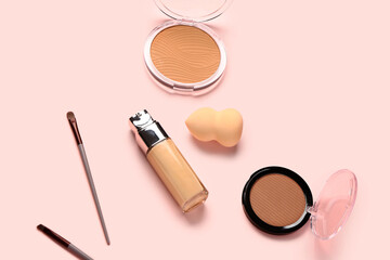 Bottle of makeup foundation with decorative cosmetics on pink background