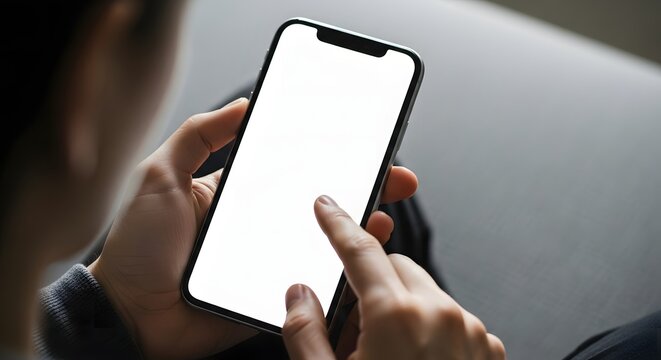 Close up of a person s hands holding and touching a modern smartphone with a blank white screen