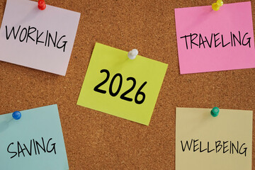 5 post-it paper pin on board with number 2026 in the middle and word working, saving, traveling, wellbeing around. new year goal target for work life balance concept