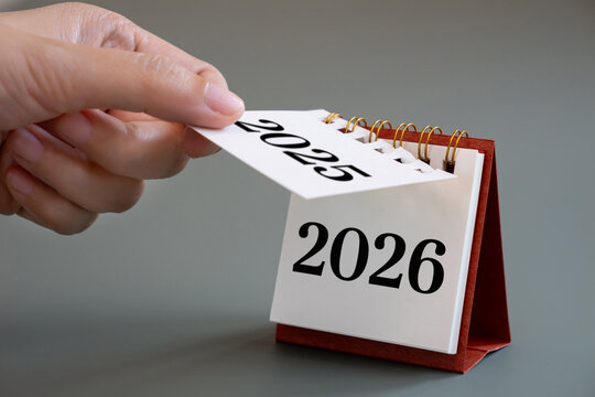 hand flipping calendar page turning from 2025 to 2026, New Year calendar concept. desk calendar flip page for new year celebration