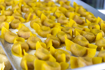 Fresh made not cooked local pasta from Bergamo casoncelli alla bergamasca, ravioli, pasta on board in local restaurant in Bergamo Citta Alta, Lombardy, North of Italy, Italian cuisine