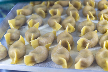 Fresh made not cooked local pasta from Bergamo casoncelli alla bergamasca, ravioli, pasta on board in local restaurant in Bergamo Citta Alta, Lombardy, North of Italy, Italian cuisine