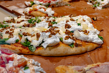 Fresh baked focaccia or pala romana pizza with vegetables, pepperone, mushrooms, tomatoes and cheese in bakery in Parma, Emilia Romania, Italy