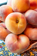 Fresh ripe sweet yellow and flat peaches Prunus persica or doughnut peach or Saturn peach