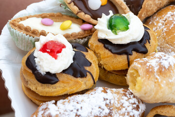 Italian sweet dessert dolce pastry and cakes with cream and fruits on plate made in artisanal bakery in Rome, Italy, close up
