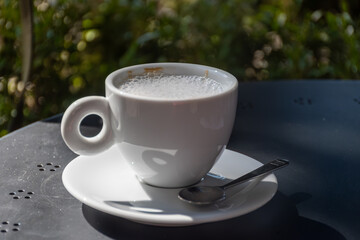 Drinking of italian coffee cappuccino served in cafe in Varenna, Como lake, Italy