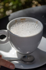 Drinking of italian coffee cappuccino served in cafe in Varenna, Como lake, Italy