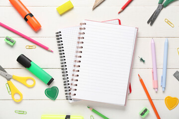 Composition with blank notebooks and stationery supplies on white wooden background, closeup